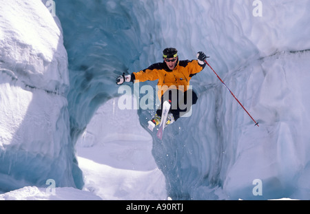 Extreme skier airborne skiing through a tunnel of ice on the glacier Mer  de Glace France Chamonix Mont Blanc Stock Photo