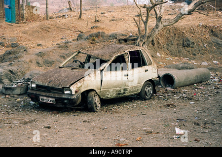 Burnt out abandoned car in India Stock Photo