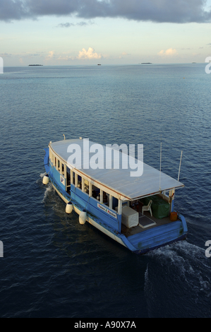 Maldives a typical dhoni boat cruising at sunset Stock Photo