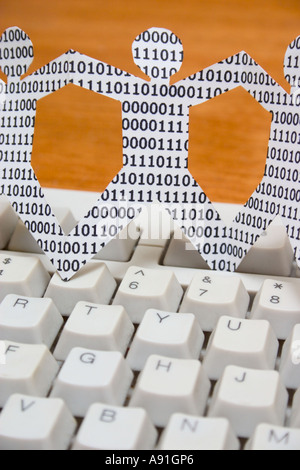 paper dolls with binary numbers on keyboard. symbolic of knowledge workers in the information technology industry Stock Photo