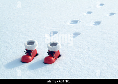 red Santa Claus Shoes in the snow Rote Nikolausstiefel im Schnee Stock Photo