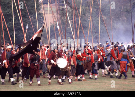 English Civil War preparing for reenactment battle by groups like English Civil War Society & Sealed Knot members as pikemen flag bearers & drummer UK Stock Photo