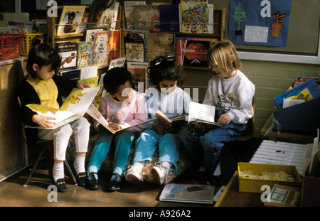 A group of children quietly reading in the book corner of the classroom Stock Photo