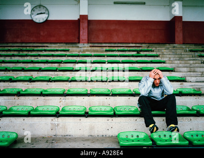 SAD LONELY YOUNG MAN IN STADIUM Stock Photo
