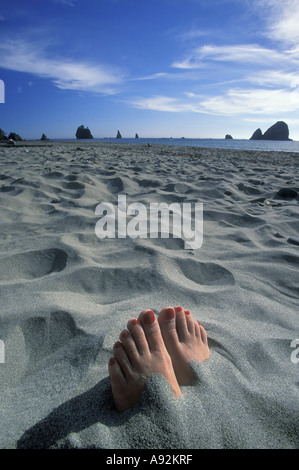 Feet buried on the sand Stock Photo - Alamy