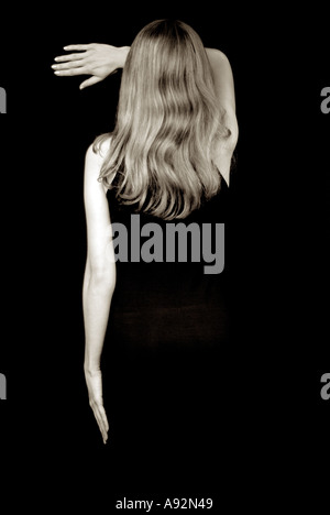 Young Woman in Black Dress Against a Black Background Stock Photo
