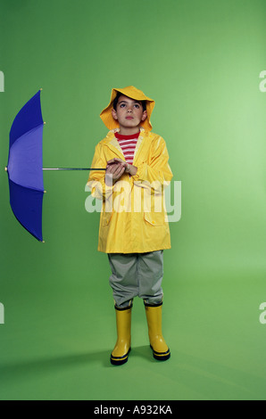 Boy wearing a raincoat and holding an umbrella Stock Photo