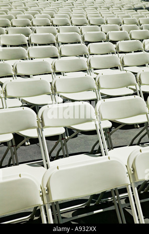 Rows of white folding chairs Stock Photo
