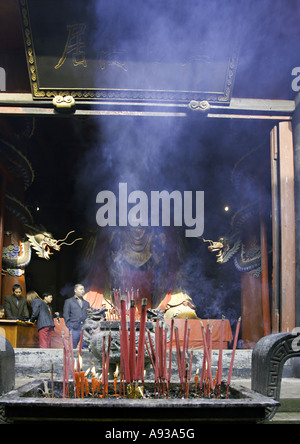 CHINA BEIJING Chinese Buddhists burn incense before a giant statue of the Buddha Stock Photo