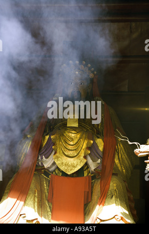 CHINA BEIJING Chinese Buddhists burn incense before a giant statue of the Buddha Stock Photo