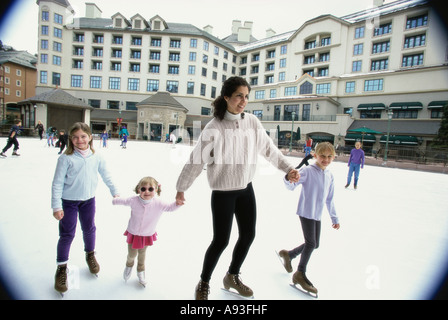 Mother ice skating with her three daughters Stock Photo