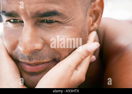 Woman cupping man's face in hands, close up Stock Photo