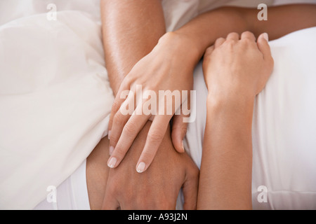 Couple embracing, lying down, mid section Stock Photo