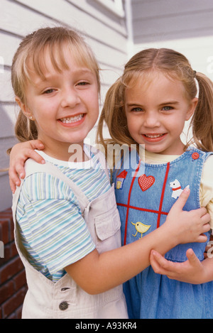 Portrait of two girls smiling and hugging each other Stock Photo - Alamy