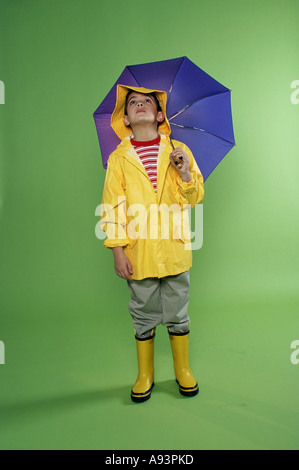 Boy wearing a raincoat and holding an umbrella Stock Photo