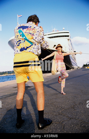 Rear view of a mid adult man and a young woman embracing each other ...