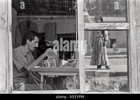 July 1987 Beytussebap south east Turkey Kurdistan A Kurdish girl is reflected in the window of a tailors shop Stock Photo