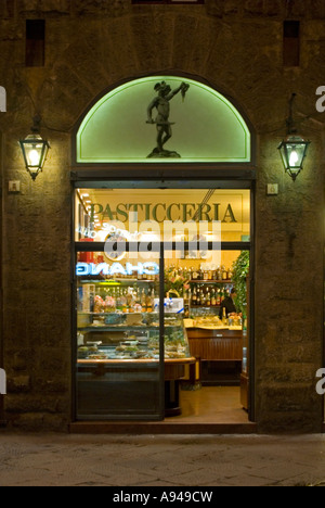 Vertical night time close up of an Italian 'La Pasticceria' front window lit up. Stock Photo