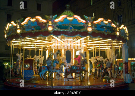 Horizontal close up of a bright glitzy old fashioned carousel at night, with motion blur as it rotates. Stock Photo