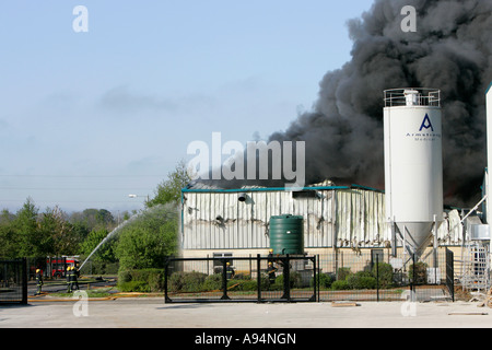 firefighters fighting a large industrial fire with water and hoses at medical warehouse coleraine Stock Photo
