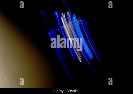 Illuminated blue star light swinging and blurred with movement. On black background. Stock Photo