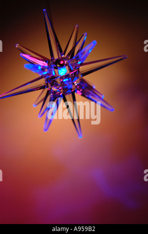 Illuminated blue star light, swinging and blurred with movement. Backlit with pink light Stock Photo