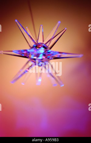 Illuminated blue star light, swinging and blurred with movement. Backlit with pink light Stock Photo