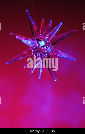 Illuminated blue star light, swinging and blurred with movement. Backlit with pink light Stock Photo