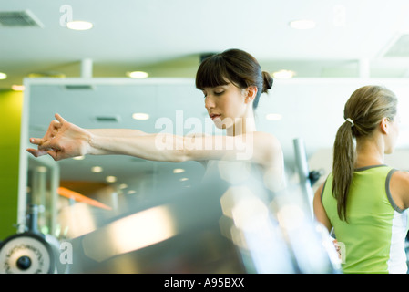 Woman stretching arms in health club Stock Photo