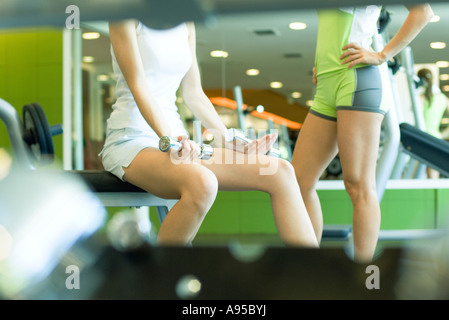 Two women standing in weight room, partial view Stock Photo