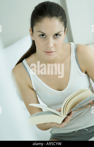 Woman holding open book, looking at camera Stock Photo