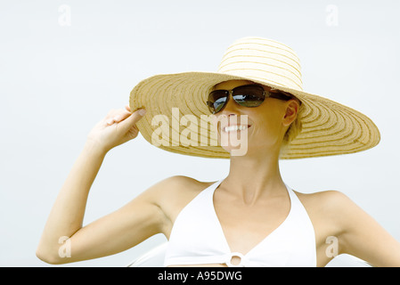 Young woman wearing sunglasses and sunhat, head and shoulders Stock Photo