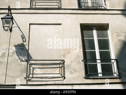 Windows in apartment building, one window filled in with concrete Stock Photo