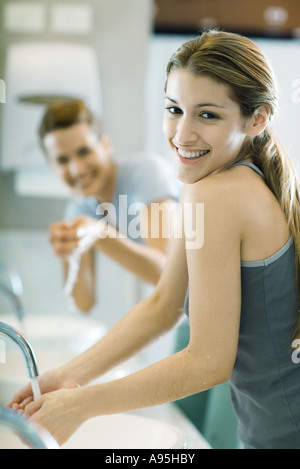 Two women washing hands in public restrooms Stock Photo