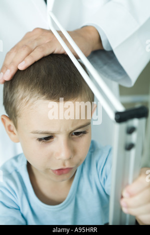 Doctor measuring boy during check-up Stock Photo