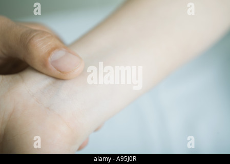 Doctor taking woman's pulse, close-up Stock Photo