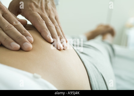 Man's hands on pregnant woman's stomach Stock Photo