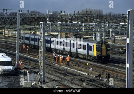 Central Trains Class 350 Desiro train passing Network Rail track workers at Rugby, Warwickshire, England, UK Stock Photo