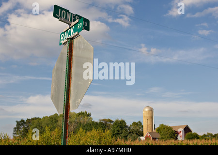 WISCONSIN Near Lake Geneva Street signs for intersection of Back Road and Jones Road atop stop sign red barn and silo Stock Photo