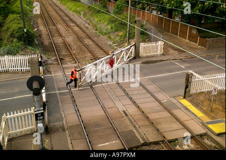 man opening a gate at a manned rail crossing Stock Photo - Alamy