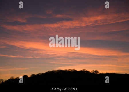 Dramatic sunset showing a Turner-like windswept sky of soft pink clouds sweeping and floating over hilltop Braunton England Stock Photo