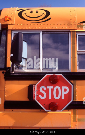 Stop: An illuminated swing out stop sign mounted on the side of a Bluebird school bus, New Hamburg, Ontario, Canada Stock Photo