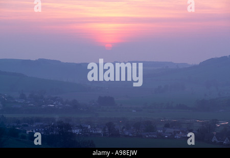 A misty hazy spring sunset over Kirk Yetholm on the edge of the Cheviot Hills in the Scottish Borders Scotland UK Stock Photo