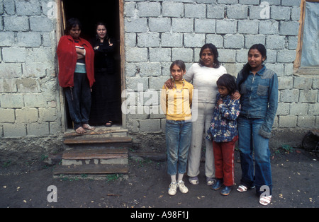 A mother and three children pose outside a house while two others look on from doorway in Gypsy village of Soard, Transylvania. Stock Photo