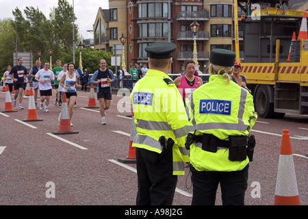 Two PSNI Officers watch runners in the Belfast Marathon 07 05 07 Stock Photo