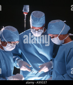 surgeon and two assistants performing a medical operation Stock Photo