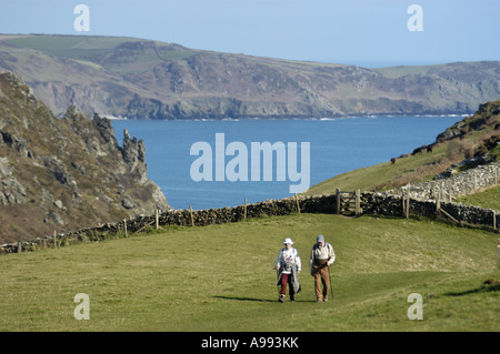 Walkers above Starehole Bay at the entrance to Salcome Harbour near Bolt Head on the South West Coast in south Devon England Stock Photo