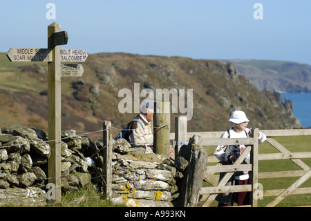 Walkers above Starehole Bay at the entrance to Salcome Harbour near Bolt Head on the South West Coast in south Devon England Stock Photo