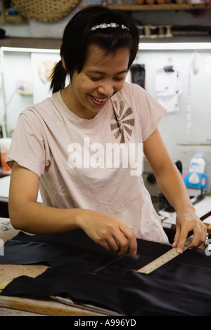 Young lady in a Bangkok sweatshop that manufactures tailored suits Thailand Stock Photo