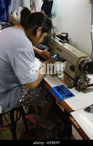 Young lady in a Bangkok sweatshop that manufactures tailored suits Thailand Stock Photo